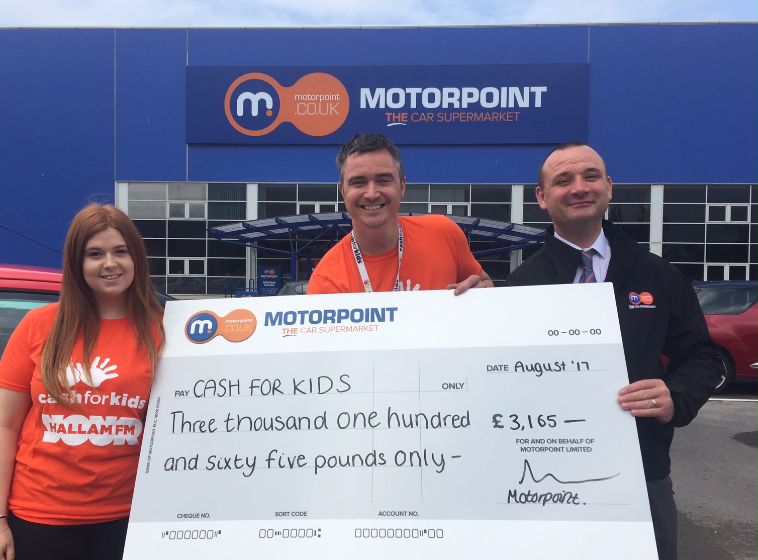 Allan Ogle, Charity Manager for Cash for Kids (centre) collects cheque from Motorpoint following the recent Drive In Cinema event at the company's newest branch Allan Ogle, Charity Manager for Cash for Kids (centre) collects cheque from Motorpoint following the recent Drive In Cinema event at the company's newest branch