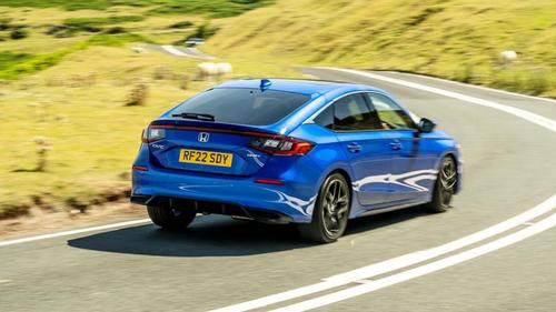 Honda Civic driving around a corner, rear view