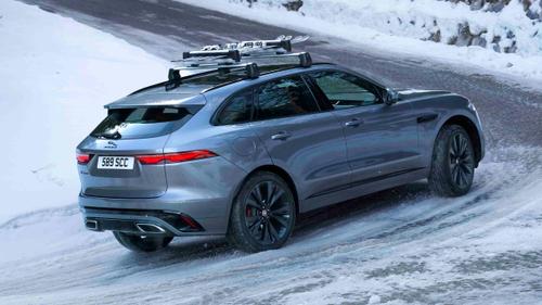Jaguar F-Pace driving on snowy road, rear view