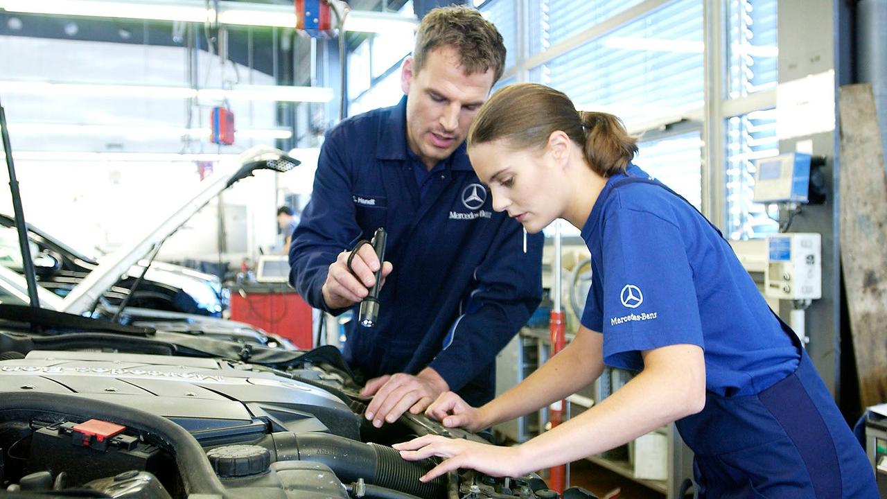 Mercedes technicians inspect engine bay