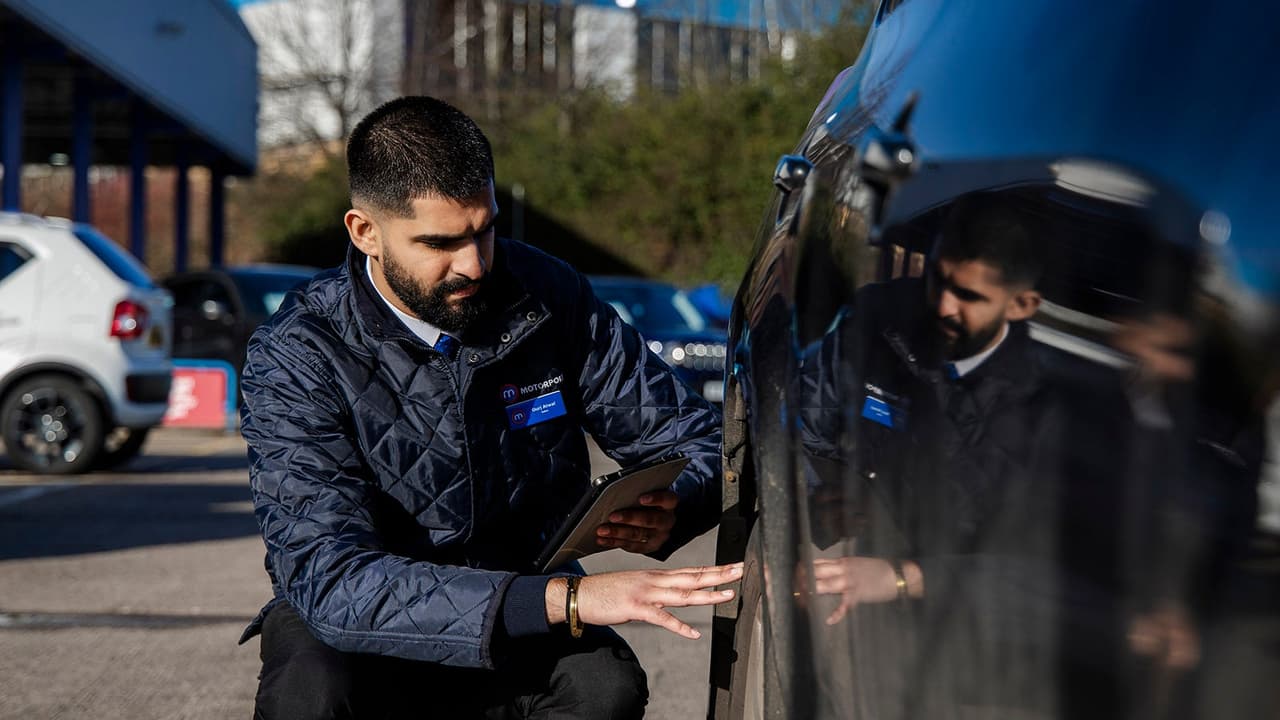 Motorpoint sales executive inspects car tyre