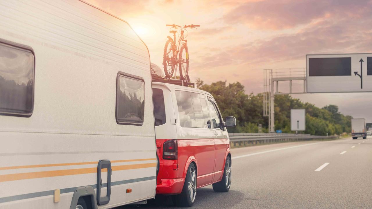 VW van towing a caravan on a motorway