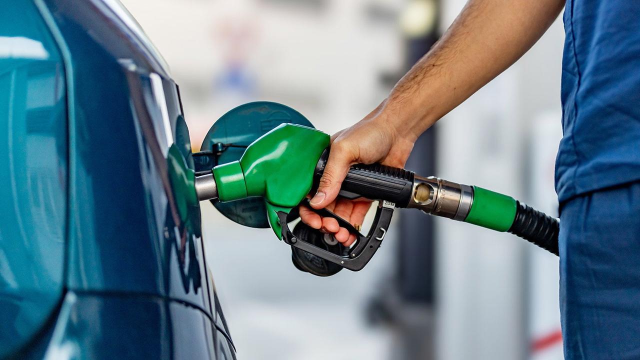 Driver refuelling petrol car from fuel pump