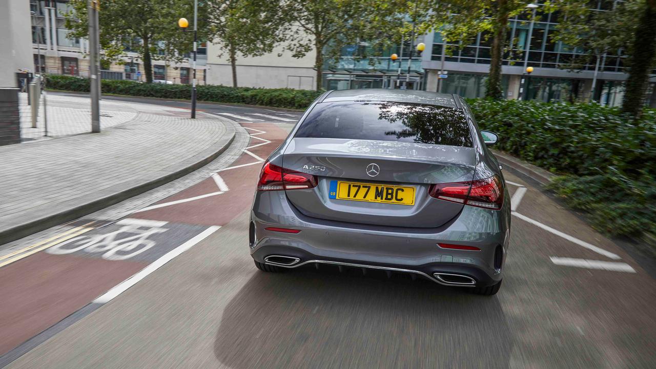 Mercedes A-Class Saloon driving through urban area, rear view