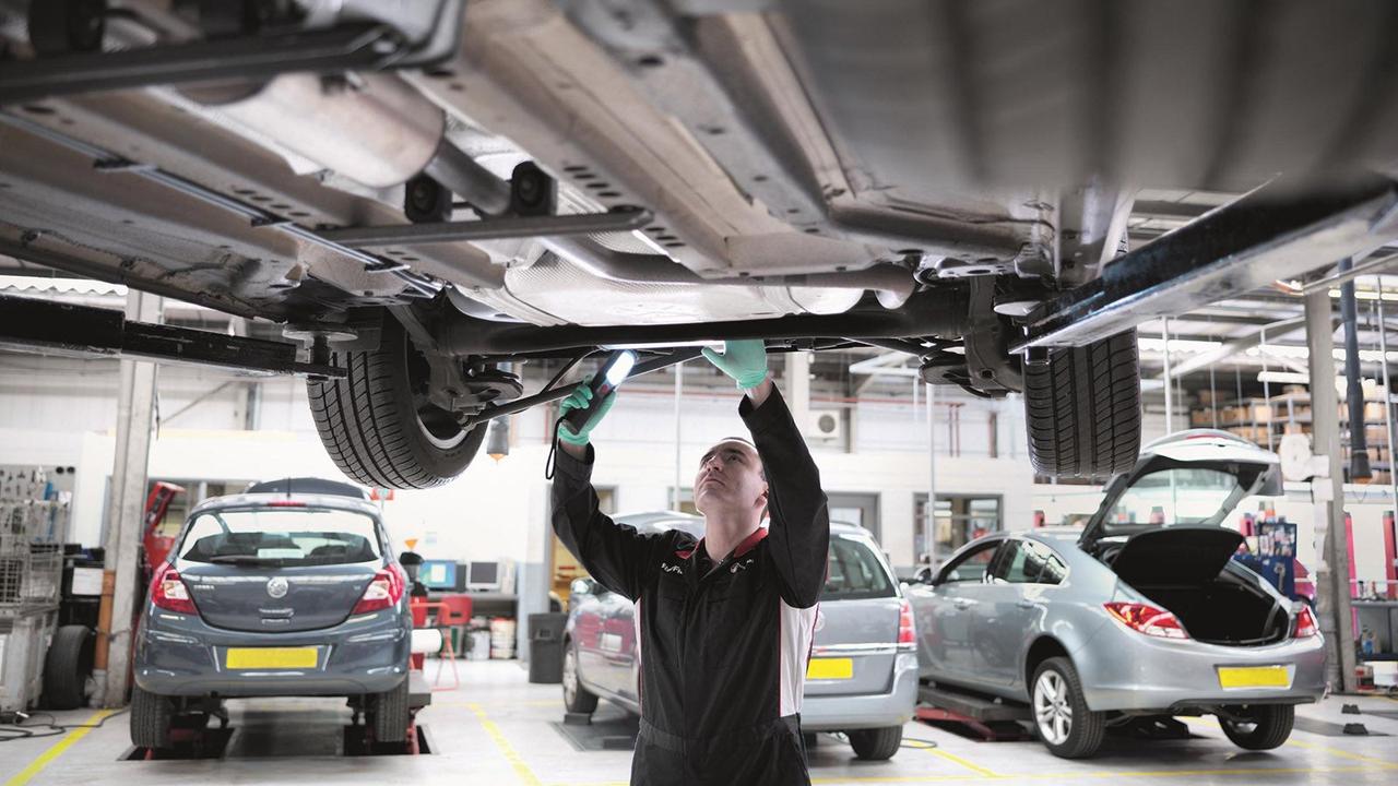 Car underside being inspected