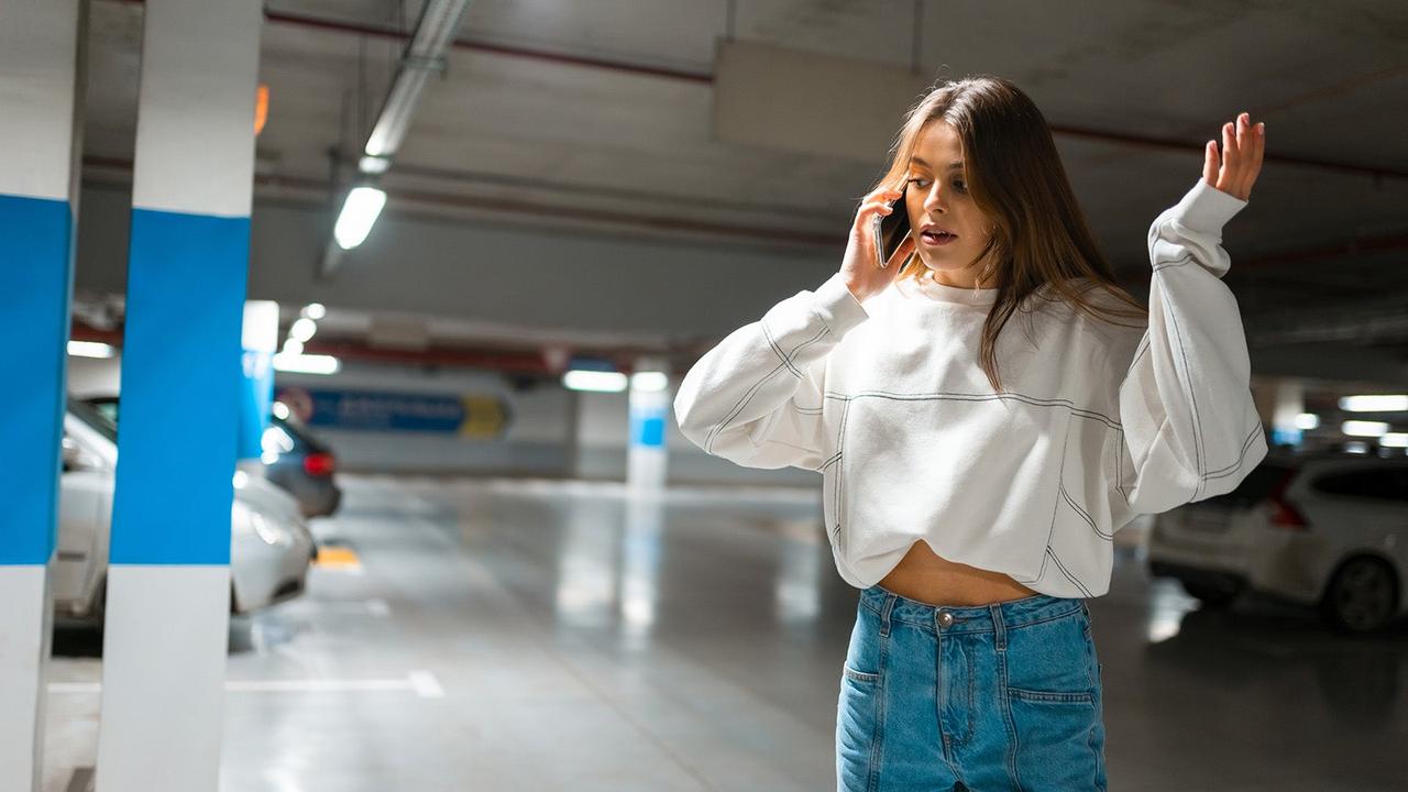 Lady speaking on phone in agitated manner after finding her car has been stolen