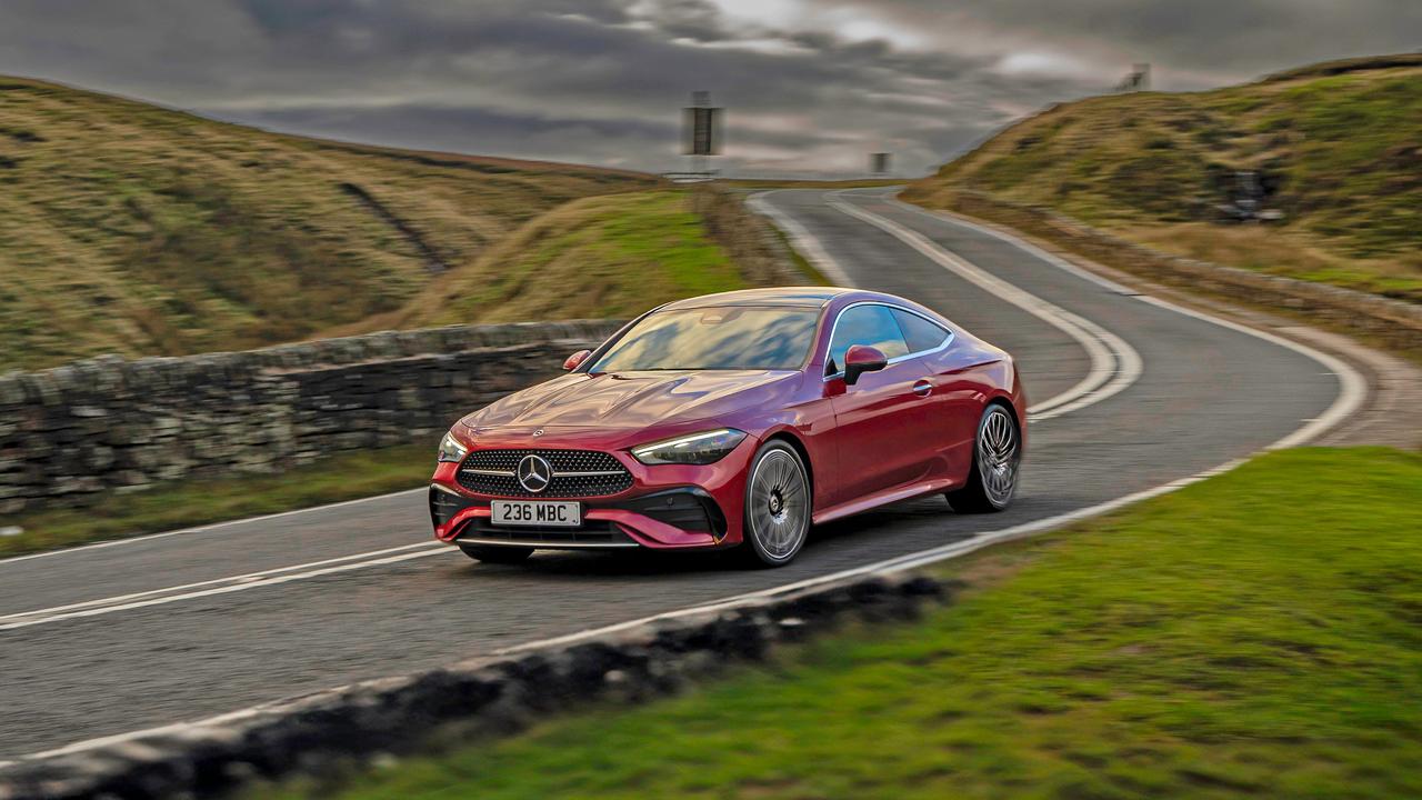 Mercedes CLE coupe driving on winding road with motion blur