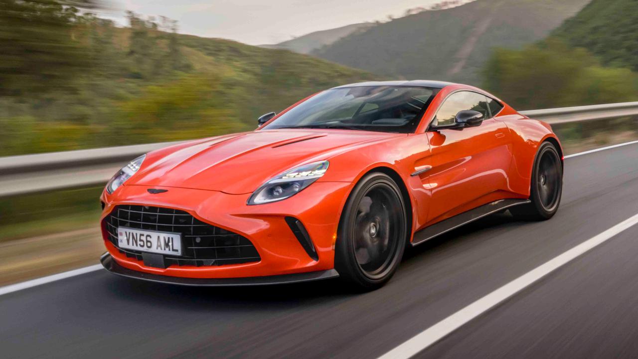 Aston Martin Vantage in orange driving on a Spanish mountain road