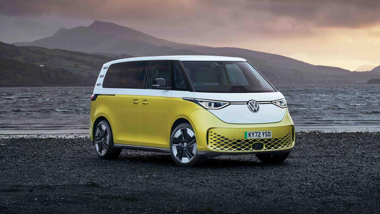 Volkswagen ID. Buzz in yellow parked on beach in front of moody mountain scenery