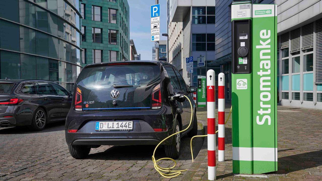 A black VW e-Up charging in Germany