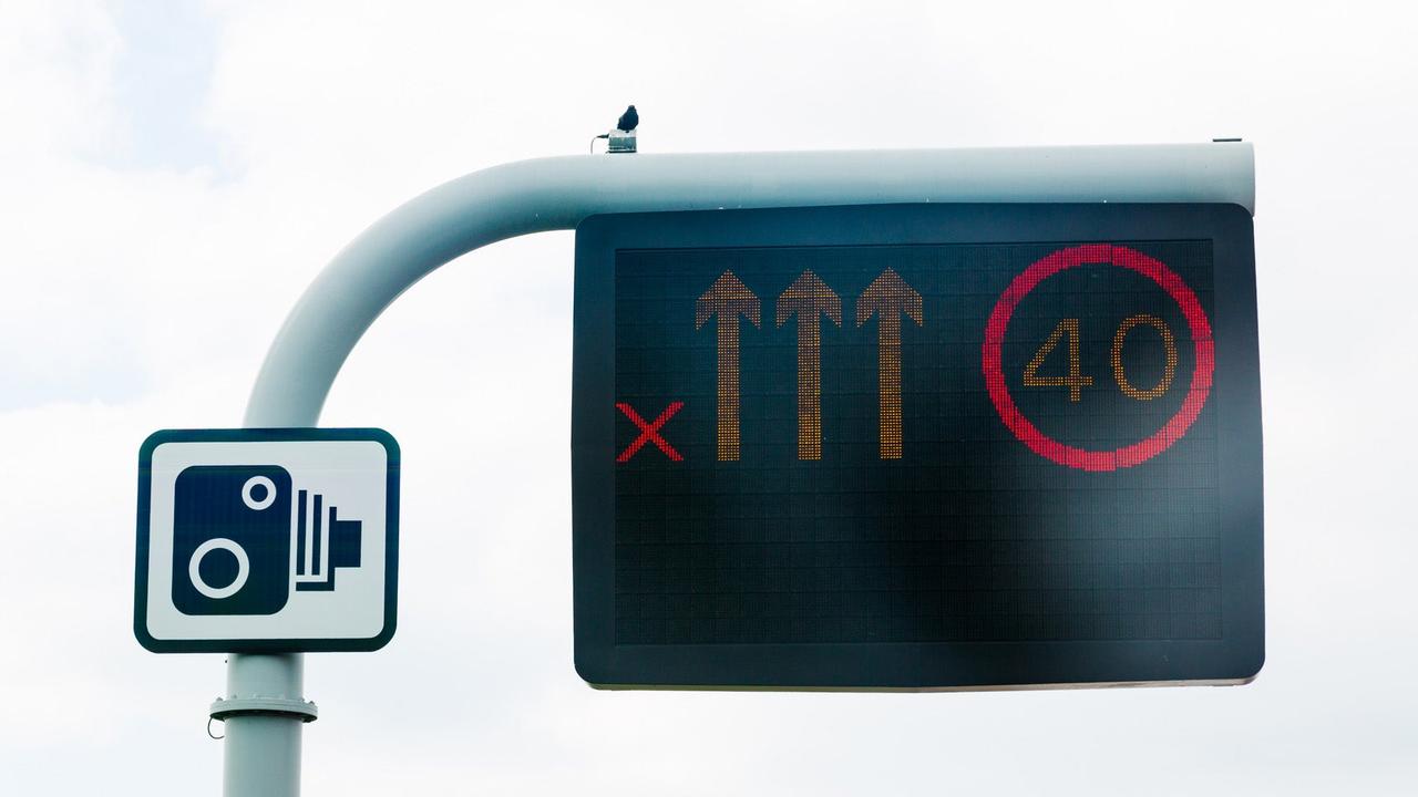 Smart motorway gantry showing 40mph speed limit and one lane closed