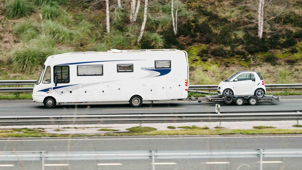 Motorhome towing a Smart car on a trailer