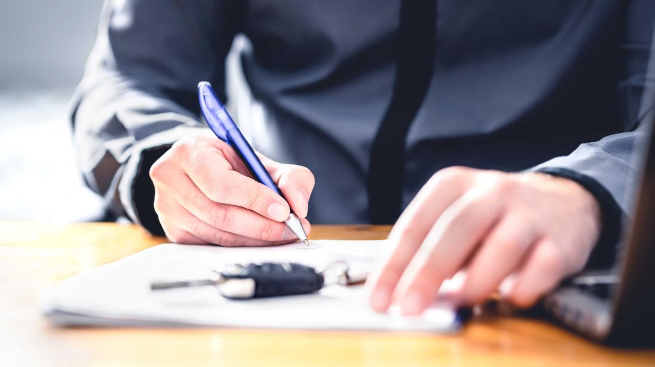 Person's hands signing car document