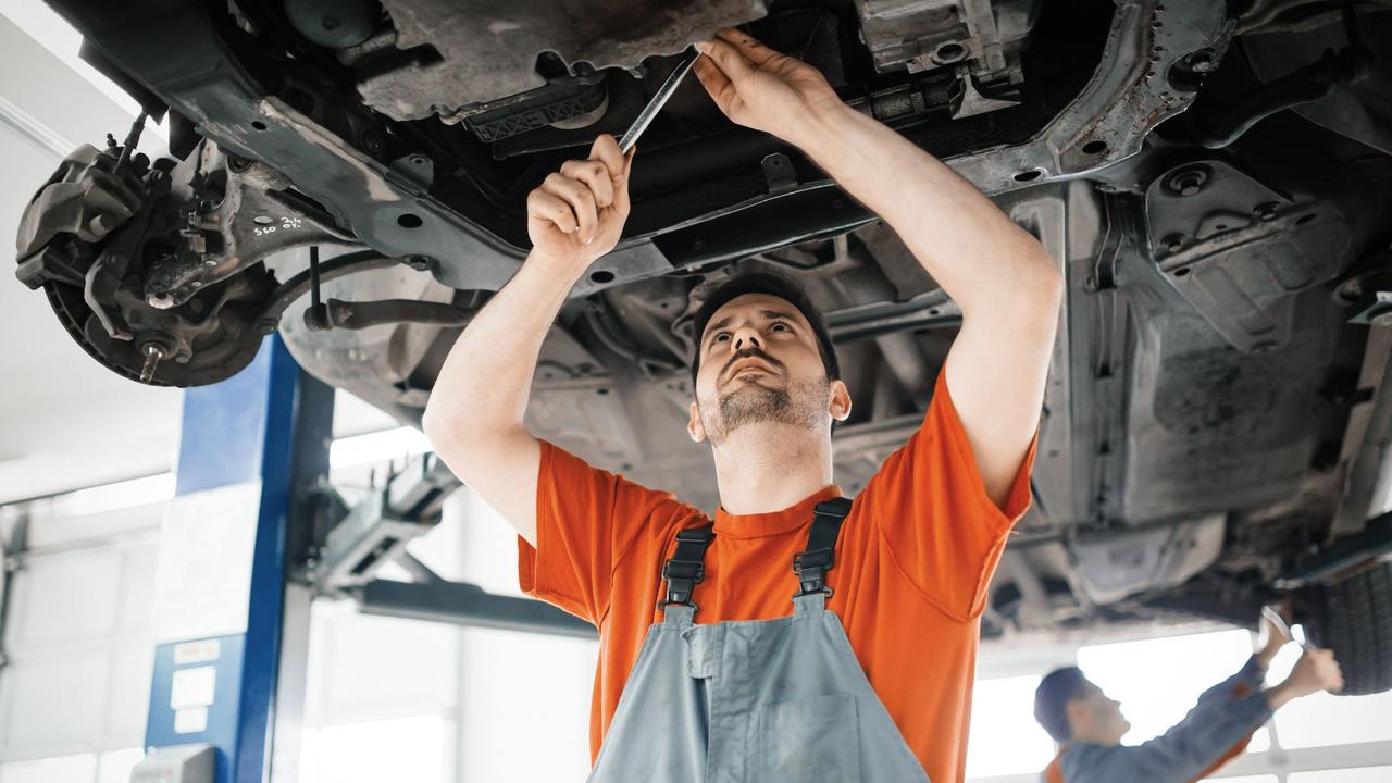 Mechanic working on underside of a car