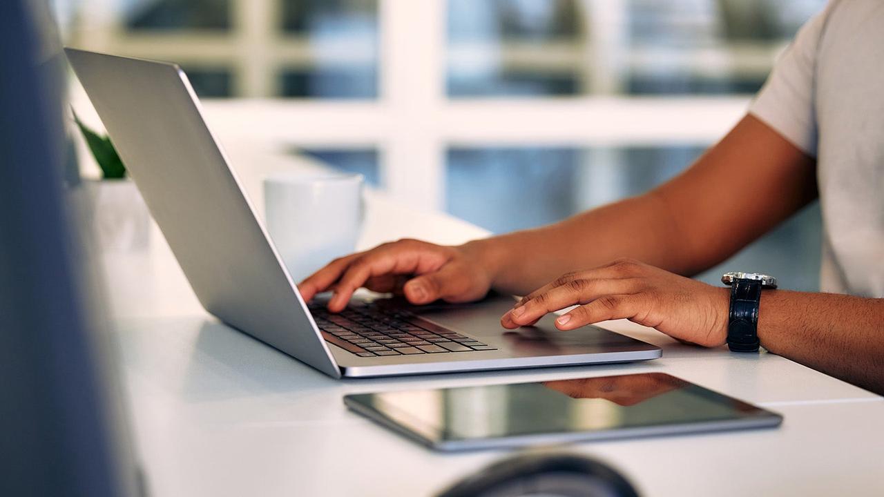 Hands typing on a laptop