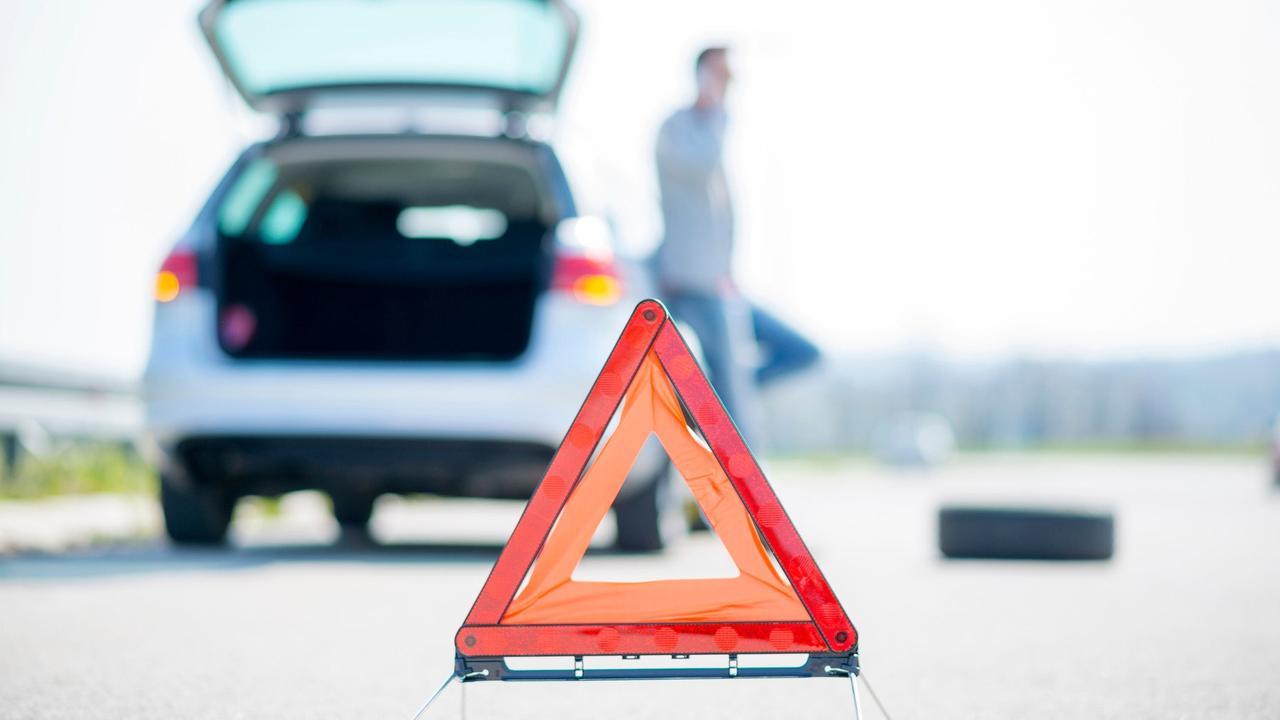 Warning triangle in front of car with hazard lights on