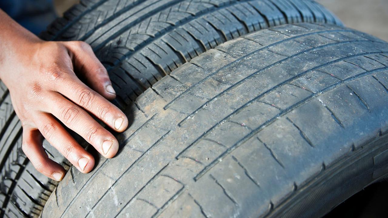 Tyre with worn tread next to a fresh tyre