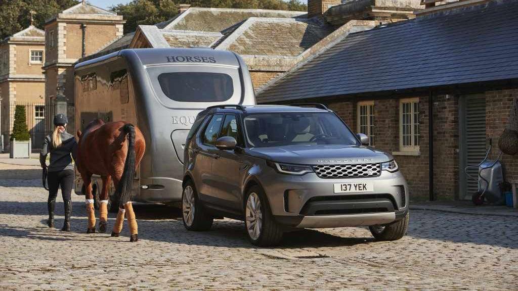 Land Rover Discovery pulling horsebox with horse nearby