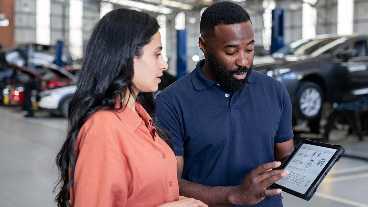 Car technician showing a customer their car report
