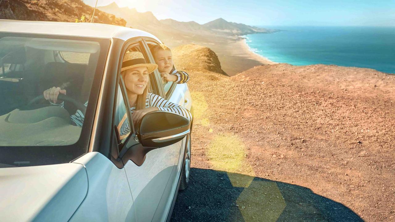 Woman and child looking out of Citroen C3 at dramatic beach scene