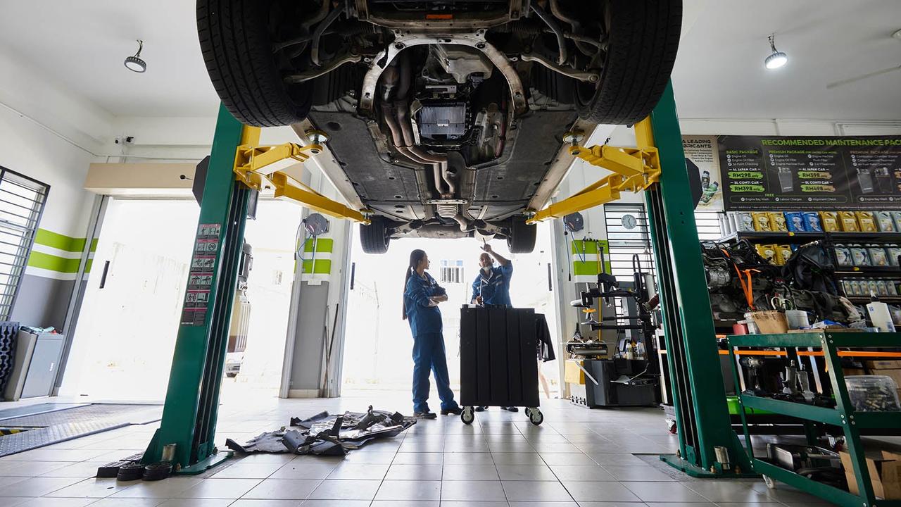 Car techs looking under car
