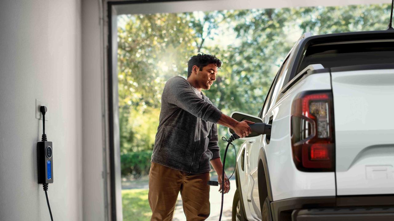 Man plugging in Ford Ranger PHEV in a garage