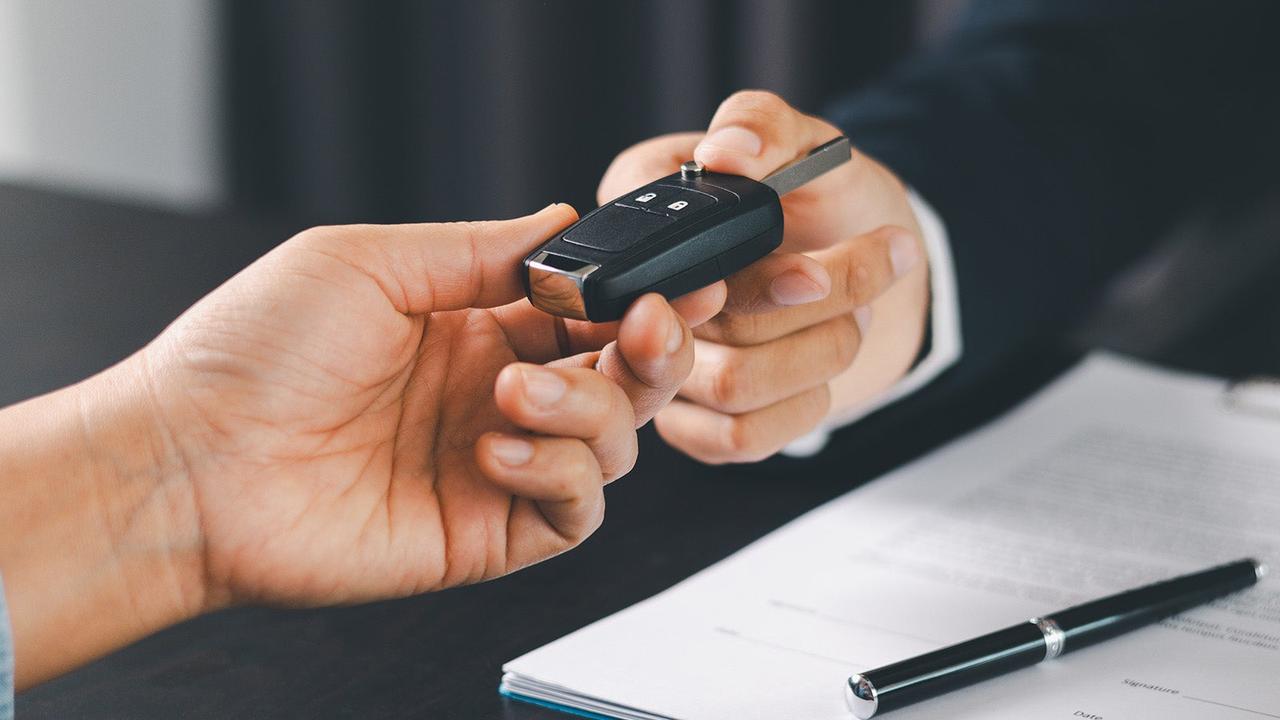 Car key being handed over by dealer