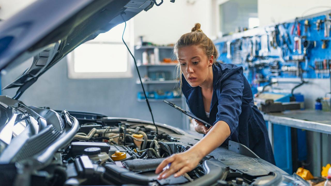 Female mechanic working on car