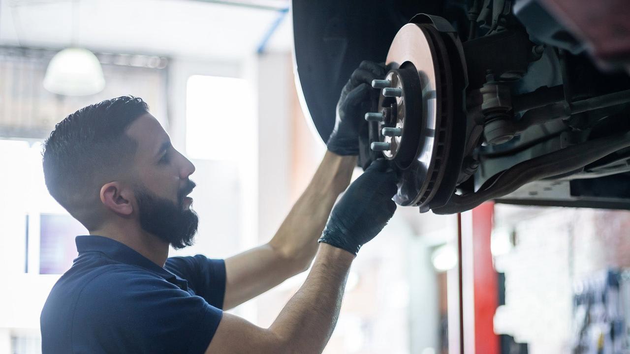 Car technician checks brakes