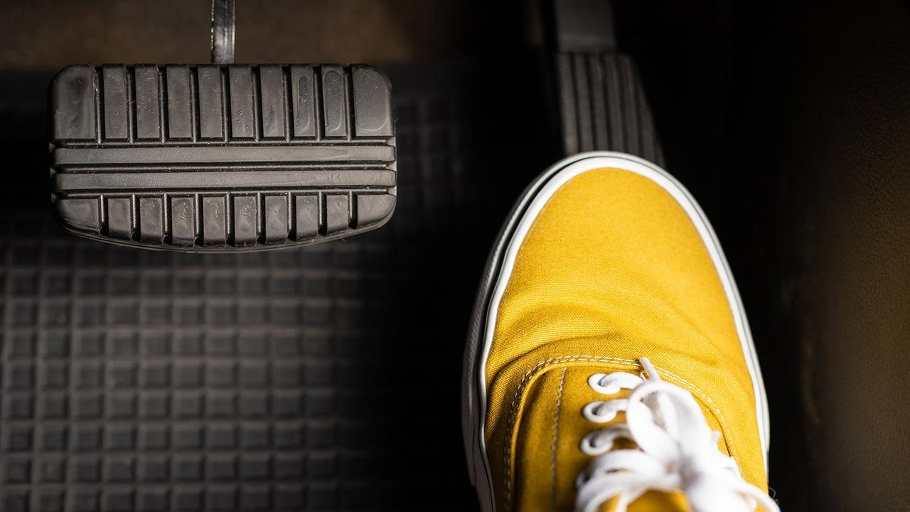 Person in yellow shoe pressing accelerator pedal