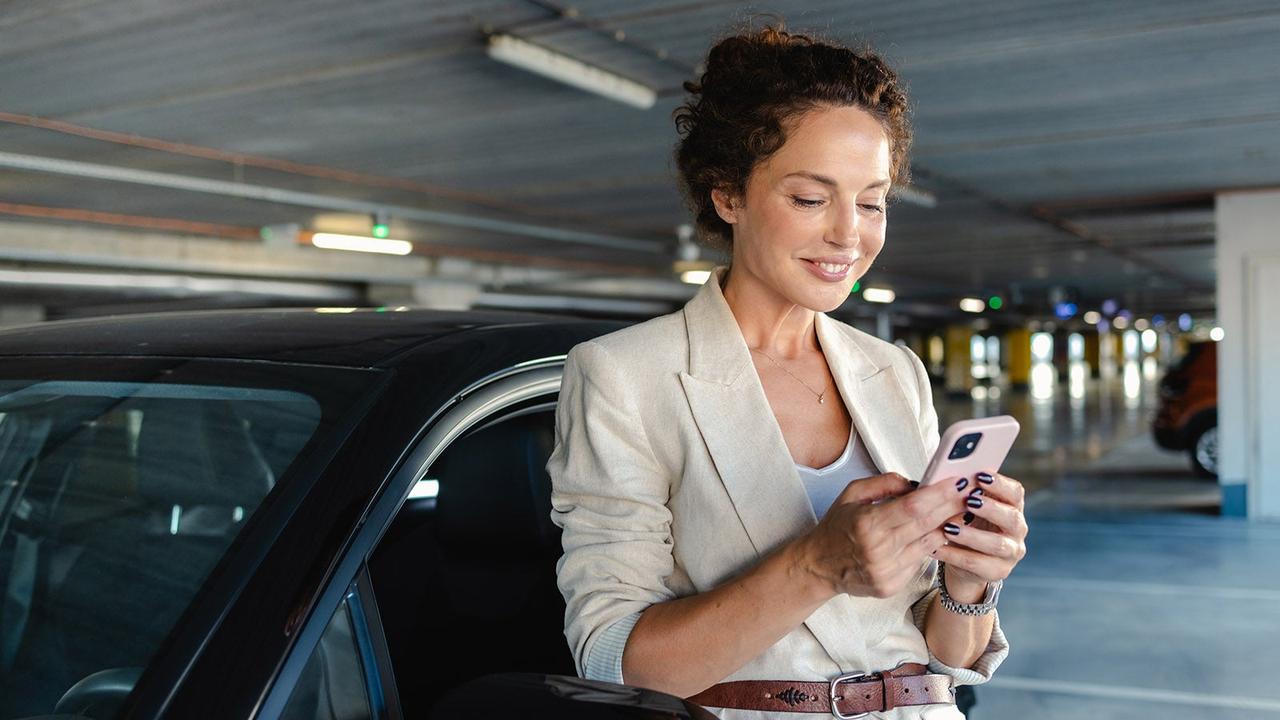 Lady on phone next to car