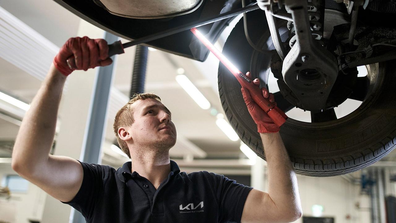Kia technician servicing a car