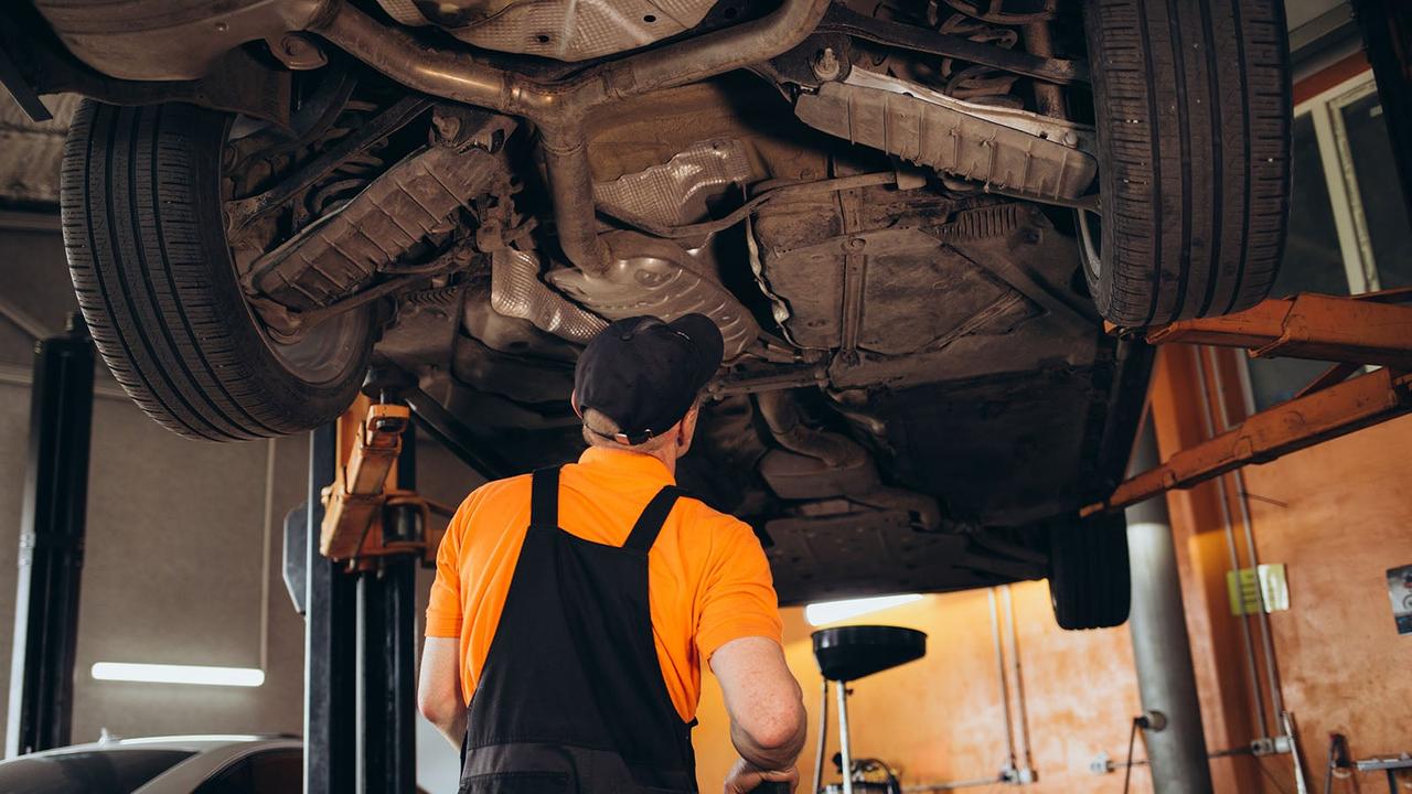 MOT tech inspecting cars