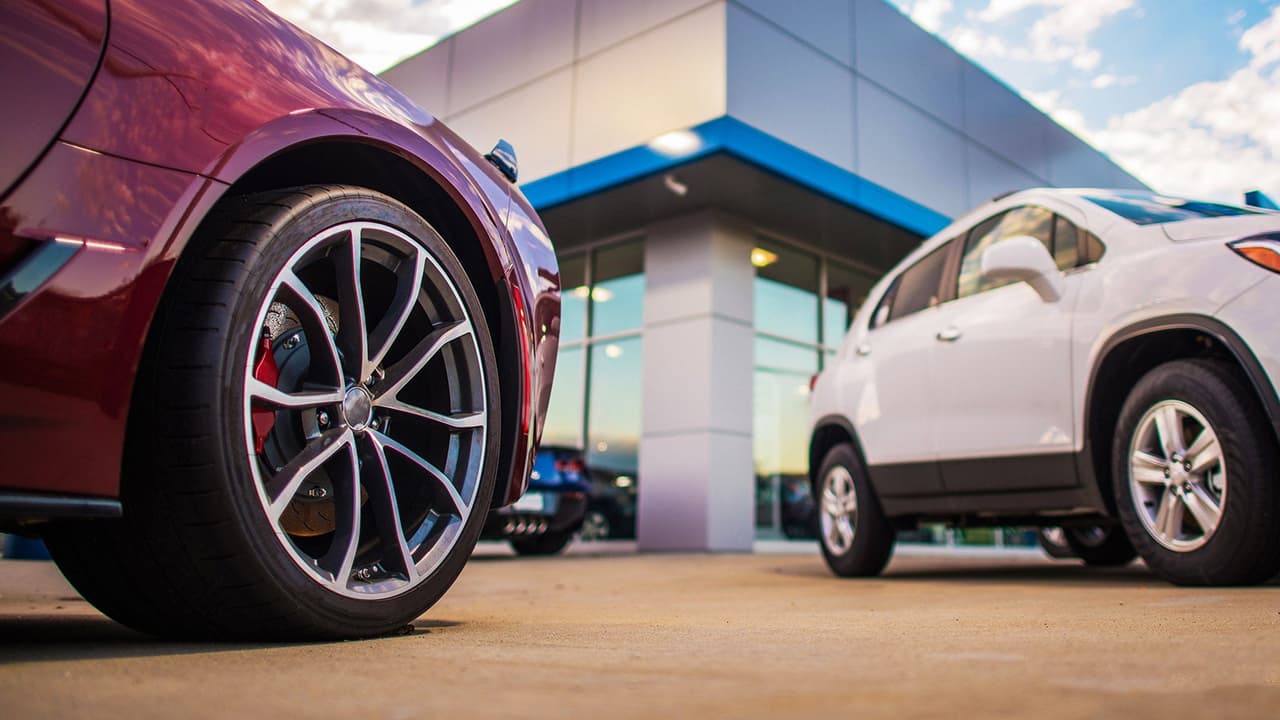 Car wheels in foreground in front of car dealership